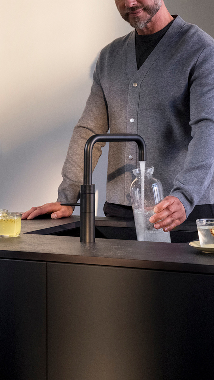 Eine Karaffe mit gekühltem prickelndem Wasser füllen